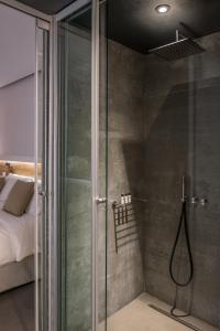 塞沃塔多莫特贴水尼古拉斯套房度假酒店的卧室里带玻璃门的淋浴