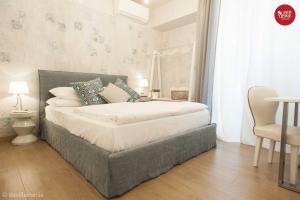 乌迪内Sleep In Udine的卧室配有1张床、1张桌子和1把椅子