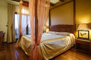 卡索拉Hotel & Spa Sierra de Cazorla 4*的一间卧室设有天蓬床和窗户。