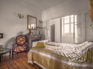 LabordePetit Château的一间卧室配有一张床、一把椅子和镜子