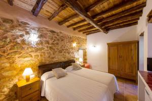 圣埃乌拉利亚埃科萨尔科乡村民宿的一间卧室设有一张床和石墙