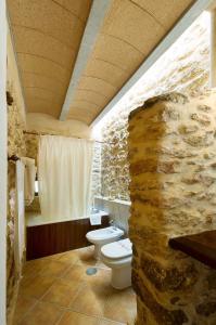 圣埃乌拉利亚埃科萨尔科乡村民宿的石质浴室设有卫生间和石墙