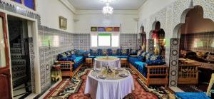 穆莱伊德里斯Gite El Menzeh的一间设有蓝色椅子和桌子的房间