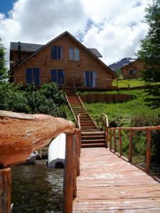 埃尔布兰科Lodge de Montaña Lago Monreal的木板人行道,通往一栋有建筑的房子