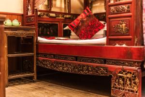 平遥Pingyao Hongyuyuan Guesthouse的一间卧室配有一张红色天蓬的木床