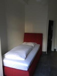 曼海姆曼海姆水塔酒店的一张位于一个红色和白色床垫的房间的床铺