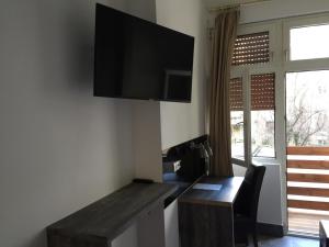 曼海姆曼海姆水塔酒店的一间设有一张桌子的房间,墙上配有电视