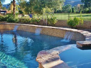 棕榈泉Palm Springs Golf Course Home Private Pool and Spa!的一座带石墙的大型游泳池