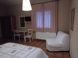 阿塞沃casa rural buenos aires的卧室配有1张床、1张桌子和1把椅子