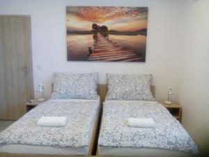 VacenoviceOaza的一间卧室设有两张床,墙上挂着一幅画