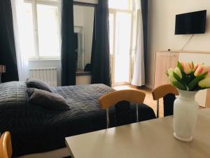 布拉格Modern cozy apartment in central Prague的一间卧室配有一张床和一张花瓶桌子