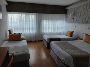 拉科鲁尼亚阿尔米兰特酒店的酒店客房设有两张床和窗户。