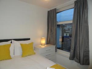 布里斯托Luckwell Too by Cliftonvalley Apartments的一间卧室配有一张带窗户和灯的床