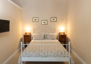 卡塔尼亚Dimora Porta Garibaldi的一间卧室配有白色床和2个床头柜