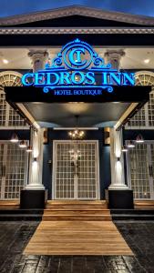 瓜亚基尔Cedros Inn Boutique Hotel的一座酒店大楼,前面有标志