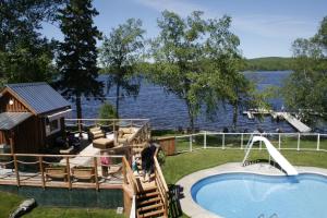 梅干提克湖Auberge et Chalets sur le Lac的一个带游泳池和房子的度假胜地