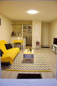 卡尔卡松Appart Chrystal的客厅配有黄色的沙发和桌子