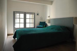贝济耶CENTRE HISTORIQUE T3 DUPLEX PARKING Gratuit的一间卧室设有一张绿色的床和一个窗户。
