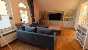 博尔库姆Haus Wopke的客厅配有蓝色的沙发和电视