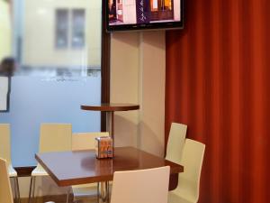 萨莫拉Hostal Bajo La Muralla的一间带桌椅和电视的用餐室