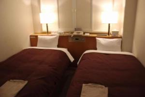 高山Country Hotel Takayama - Vacation STAY 67710的配有两盏灯的小房间内的两张床