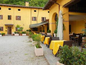 TeoloAgriturismo Ca Noale的一间设有桌椅的餐厅,一座黄色的建筑