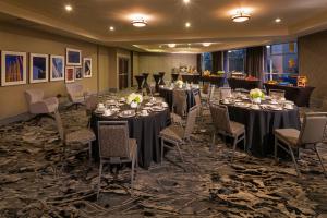 西雅图西雅图百老汇银云酒店 的宴会厅配有长桌和椅子