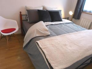 Hallennes-lès-Haubourdinle 99B Modern apartment queen size bed connected TV的一间卧室配有一张大床和红色椅子