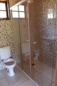 布埃诺布兰当Chalés Cachoeira Cafundó的一间带卫生间和玻璃淋浴间的浴室