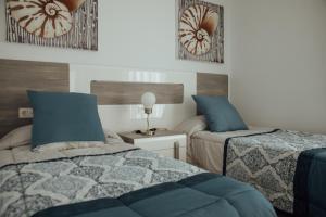 塞博河畔卡莱塔Apartamento Cuesta del salado的一间卧室配有两张带蓝色枕头的床