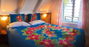 阿鲁坦加帕拉蒂斯湾旅舍的一张带鲜花的蓝色棉被的床