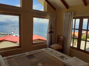 Isla de SolJACHA INTI的一间卧室设有一张床和两个大窗户