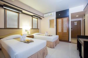 七岩亚洲查安酒店的酒店客房设有两张床和电视。