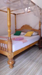 坦加拉Sasagara Beach Villa的一间卧室配有一张木床和天篷