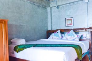 塔可克海滩Baan Tubkaek Hotel的一间卧室配有带白色床单和枕头的床。