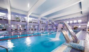 纳洛克Sanatorium Naroch的大楼内一个带滑梯的大型游泳池