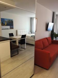 克拉根福305 Berlin, Studio Apartment, 38m2 2-4 Pers的一间带红色沙发的客厅和一间卧室