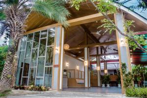 拉威海滩Lady Naya Villas - SHA Extra Plus的一座带大窗户和棕榈树的建筑