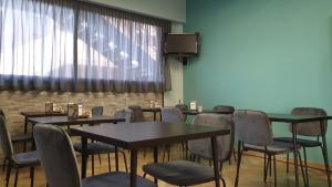 圣马力诺多加纳酒店的一间带桌椅和电视的用餐室