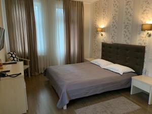 布恰维多利亚公园酒店的一间卧室设有一张大床和一个窗户。