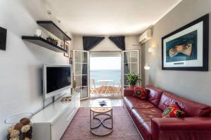 皮内达德马尔Apartment in front of the Beach的客厅配有红色皮革沙发和电视