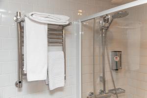 摩尔曼斯克AZIMUT City Hotel Murmansk的带淋浴和白色毛巾的浴室