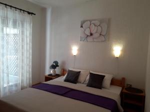 斯维蒂尤拉伊Delfin Apartments的卧室配有一张挂有花卉画的床铺。