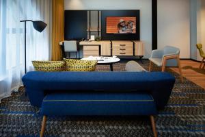 大阪Citadines Namba Osaka的客厅配有蓝色的沙发和电视