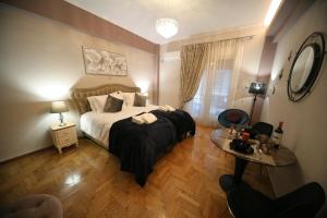 雅典Denise Luxury Apartment-Centre of Athens,Kolonaki的一间卧室配有一张大床和一张桌子