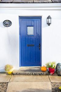 CarrowauffBlue Stonecutters Cottage, Doolin的白色房子的蓝色门,带南瓜