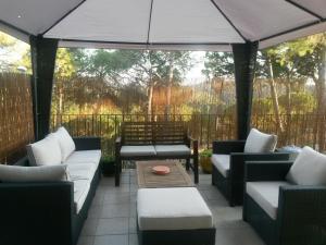 巴古尔Villa Hermosa的天井配有沙发、桌子和遮阳伞。