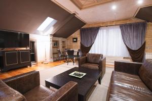 贝尔格莱德Eclat Luxury Rooms的客厅配有皮革家具和平面电视