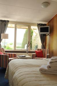 弗洛德罗普洛德比克尔豪夫住宿加早餐旅馆的酒店客房带一张床、椅子和电视