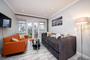 曼彻斯特Beautiful Cozy Home With Free Parking的客厅配有大沙发和橙色椅子